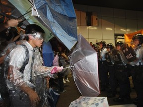 A student protester in his school uniform stands off with riot police inside a vehicle tunnel as pro-democracy protesters stormed in to block a road leading to the financial Central district in Hong Kong October 14, 2014. (REUTERS/Stringer)