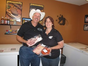 Mike and Joanne Buis hold a few examples of the frozen beef products that they sell from their on-farm store.