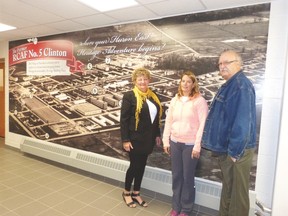 Economic development officer for the Municipality of Huron East, Jan Hawley, Vanastra Recreation Centre manager, Lissa Berard and Vanastra resident, Nigel Dezell, pose for a shot in front of a new mural designed to celebrate the former RCAF Clinton Base at the Vanastra Recreation Centre.