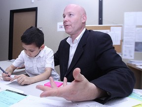 Jason Schreyer has won election in Elmwood-East Kildonan. He's seen here working in his campaign office on Stadacona Street with son Jared, 5, on his lap on Wed., Oct. 15, 2014.