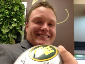 Huskies centre Shawn Walter poses with a souvenir ball from the Edmonton Eskimos Wednesday at the Shaw Conference Centre. (Gerry Moddejonge, Edmonton Sun)