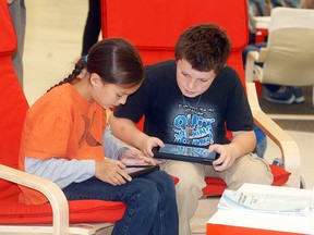 A.A. Wright public school students Noble Boissoneau, left and Trenton Knight collaborate on a project on their iPads in the school's learning commons on Oct. 8.