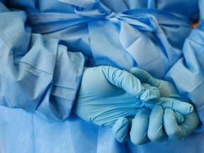 The gloved hands of an army nurse are seen during a demonstration of an isolation chamber for the treatment of infectious disease patients.

REUTERS/Ralph Orlowski