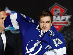 Jonathan Drouin puts on a Tampa Bay Lightning jersey after he was selected by the Lightning in Newark, New Jersey, June 30, 2013. REUTERS/Brendan McDermid