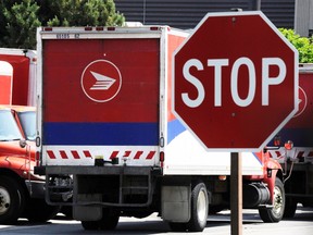 Mail trucks are seen as they are parked behind a stop sign after the Canadian Union of Postal Workers (CUPW) were locked out at a Canada Post sorting facility in Toronto.

REUTERS/Mark Blinch/Files