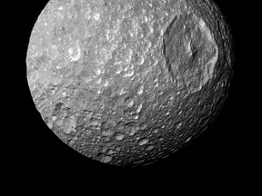 The Saturn moon Mimas is seen in an image from NASA's Cassini spacecraft taken at a distance of about 9,500 kilometers (5,900 miles) February 13, 2010. Saturn's battered moon Mimas may sport a thin global ocean buried miles beneath its icy surface, raising the prospect of another life-friendly habitat in the solar system, scientists said on Thursday.  REUTERS/NASA/JPL-Caltech/Space Science Institute/Handout via Reuters
