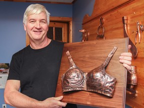Kevin Fredricks, owner of Davar Bronzing, holds the mounted bronzed bra he made for the Breast Cancer Action Kingston 3rd annual fundraising event. The fundraising event will be held at Taylor Automall on Oct. 25 and will include more than 50 silent auction items. (Julia McKay/The Whig-Standard)