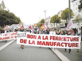Imperial Tobacco-Seita employees protest against the closing of the cigarette plant in Carquefou, France while attending a nationwide protest day against the French government?s austerity reforms in Nantes, on Thursday. The banners reads: ?Don?t close the factory.? (Stephane Mahe/Reuters)