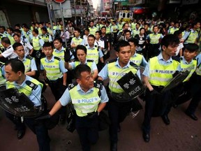 Police advance as they try to disperse the crowd after removing barricades at a protest site in Mongkok shopping district in Hong Kong October 17, 2014. REUTERS/Carlos Barria