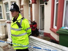 A police officer stands outside a house in Portsmouth, England, Oct. 14, 2014. British police have made arrests over the past two weeks as part of a counter-terrorism operation. (KIERAN DOHERTY/Reuters)