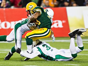 John White gets hauled down by Saskatchewan tacklers last month (Codie McLachlan, Edmonton Sun).