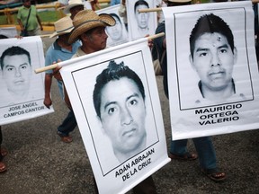 People carry photographs of missing students during a march in Acapulco October 17, 2014. Thousands of students and teachers took to the street demanding the government find 43 students missing since last month's deadly clashes. On September 26, police allegedly linked to a criminal gang shot dead at least three students and abducted dozens of others during clashes in the southwestern city of Iguala. Forty-three of the students are still missing.  REUTERS/Jorge Dan Lopez