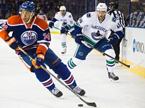 Edmonton's Darnell Nurse (74) is pursued by Vancouver's Nicklas Jensen (46) during the Edmonton Oilers' NHL pre-season hockey game against the Vancouver Canucks at Rexall Place in Edmonton, Alta., on Thursday, Oct. 2, 2014. Codie McLachlan/Edmonton Sun/QMI Agency