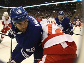 Maple Leafs’ Daniel Winnik (left) goes in against the boards with Red Wings’ Gustav Nyquist on Friday night at the Air Canada Centre. (JACK BOLAND/TORONTO SUN)