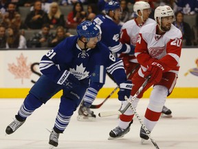 The Leafs' Phil Kessel is checked by the Red Wings' Brian Lashoff off the face-off on Oct. 17, 2014. (Jack Boland/Toronto Sun)