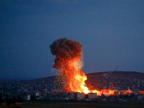 Smoke and flames rise over Syrian town of Kobani after an airstrike, as seen from the Mursitpinar border crossing on the Turkish-Syrian border in the southeastern town of Suruc in Sanliurfa province, October 18, 2014. REUTERS/Kai Pfaffenbach