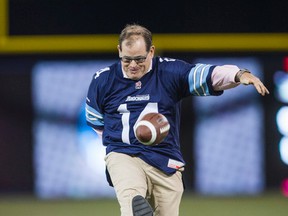 Toronto Sun Publisher Mike Power performs the ceremonial kickoff at the 20-yard line in support of women's cancer before the game on Oct. 18, 2014 between the Toronto Argonauts and the Montreal Alouettes (Ernest Doroszuk/Toronto Sun)