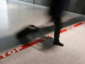 A traveller walks past the red stop line.

REUTERS/Gonzalo Fuentes