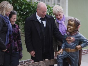 A life-size statue memorializing five-year-old abuse victim Jeffrey Baldwin was unveiled in Greenwood Park on Oct. 18, 2014.. It was an emotional moment for everyone there, including (left to right) area resident Belynda Blyth, artist Ruth Abernathy, Todd Boyce, the Ottawa man who spearheaded the idea for the bronze statue, and local City Councillor Paula Fletcher. (CHRIS DOUCETTE/TORONTO SUN)