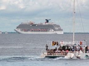 Tourists enjoy a ride on a catamaran as cruise ship Carnival Magic is seen near the shores of Cozumel October 17, 2014.

REUTERS/Stringer