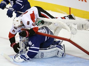 Ottawa Senators right wing Bobby Ryan tumbles over the net landing on Toronto Maple Leafs goalie Jonathan Bernier at the Air Canada Centre in Toronto, Oct. 5, 2013. (USA Today)