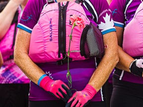 A breast cancer survivor holds a rose after taking part in the Pink Ribbon Challenge, which saw survivors form into teams for a dragon boat race, during the final day of the 18th annual Edmonton Dragon Boat Festival at Louise McKinney Park in Edmonton, Alta., on Sunday, Aug. 17, 2014. Codie McLachlan/Edmonton Sun/QMI Agency