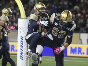 Winnipeg Blue Bombers QB Robert Mavre (left) and OL Steve Morley celebrate Paris Cotton's touchdown run against the Calgary Stampeders during fourth-quarter CFL action at Investors Group Field in Winnipeg, Man., on Sat., Oct. 18, 2014.