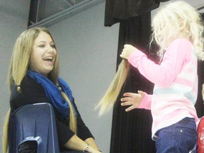 Wendy Morningstar looks on as kindergartener Jaidyn Blankenship holds a cut lock of the Sir John Moore school teacher's hair. Morningstar was donating 10 inches to Locks of Love and the top fundraisers in the Corunna school's recent Terry Fox Run were rewarded with administering her haircut. TYLER KULA/ THE OBSERVER/ QMI AGENCY