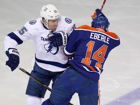 Oilers winger Jordan Eberle collides with Tampa Bay's Matthew Carle during first-period action Monday at Rexall Place. (David Bloom, Edmonton Sun)