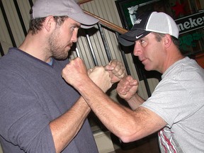 Dillon "Big Country" Carman, of Madoc, compares fists with local sponsor Kevin Putnam of Quinte Roofing during a pre-fight promotion Monday at Slapshots Sports Bar and Grill. On Saturday, Carman fights for the Canadian heavyweight boxing title in Toronto. (Paul Svoboda/ The Intelligencer)