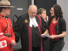 Valerie Cressman smiles after receiving a certificate of Canadian citizenship from citizenship judge George Springate at a ceremony at St. Patrick's high school Tuesday. She was one of 23 new Canadians taking part in the ceremony. Also pictured is RCMP Const. Dmitri Malakhov. TYLER KULA/ THE OBSERVER/ QMI AGENCY