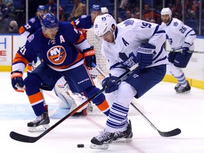 Toronto Maple Leafs right wing Joffrey Lupul (19) plays the puck in front of New York Islanders right wing Kyle Okposo (21) during the first period at Nassau Veterans Memorial Coliseum Oct 21, 2014, in Uniondale, N.Y. (Brad Penner-USA TODAY Sports)