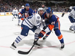 Islanders’ Brock Nelson (right) is held back by Maple Leafs defenceman Stephane Robidas in Uniondale, N.Y., last night. (AFP)