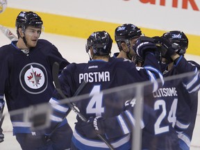 Winnipeg Jets left winger Adam Lowry (l) celebrates his first period goal against the Carolina Hurricanes with teammates Winnipeg Jets defenceman and Grant Clitsome during NHL hockey in Winnipeg, Man. Tuesday, October 21, 2014.
Brian Donogh/Winnipeg Sun/QMI Agency