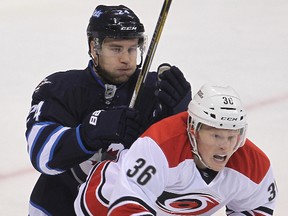 Winnipeg Jets defenceman Grant Clitsome (l) checks Carolina Hurricanes center Patrick Brown during NHL hockey in Winnipeg, Man. Tuesday, October 21, 2014.
Brian Donogh/Winnipeg Sun/QMI Agency