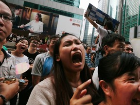 Anti-Occupy residents yell at pro-democracy protesters who have blocked a main road for weeks at Mongkok shopping district in Hong Kong October 22, 2014. (REUTERS/Bobby Yip)