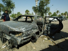 This September 24, 2007 file photo shows an Iraqi as he looks at a burnt car on the site where Blackwater guards who were escorting US embassy officials opened fire in the western Baghdad neighbourhood of Yarmukh. (AFP PHOTO/ALI YUSSEF)