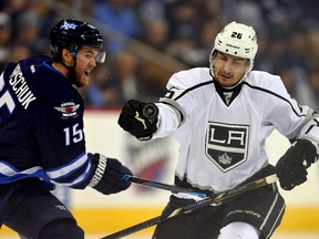 Los Angeles Kings defenceman Slava Voynov (26) battles Winnipeg Jets forward Matt Halischuk for a loose puck during NHL play at MTS Centre. (Bruce Fedyck/USA TODAY Sports)