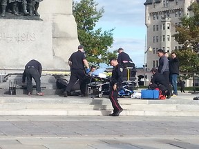 Emergency crews attend to a soldier who was shot while standing guard at Ottawa's War Memorial near Parliament Hill in Ottawa on Wednesday Oct. 22, 2014.  Jon Willing/Ottawa Sun/QMI Agency