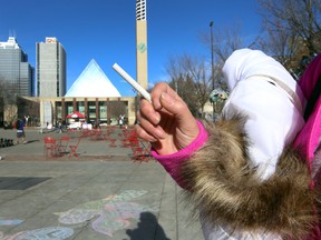 A woman holds a cigarette at Churchill Square in Edmonton, Alberta on Wednesday, October 22, 2014. Edmonton City Council has voted to ban smoking in the Square.  Perry Mah/Edmonton Sun