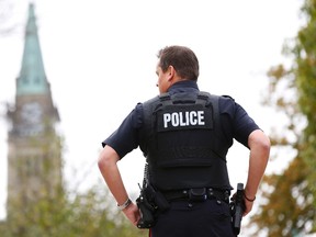 A police officer stands guard with the Peace Tower in the background following shootings in downtown Ottawa October 22, 2014. (REUTERS/Blair Gable)