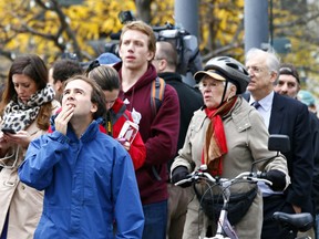 Members of the public watch the scene near Parliament Hill in Ottawa on Wednesday Oct. 22, 2014. An arrest has been made after at least one person was shot in a hail of gunfire on Parliament Hill and the nearby cenotaph. Errol McGilhon/Ottawa Sun/QMI Agency
