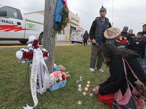 A small number of people assembled near the storage facility, in Winnipeg,  where the remains of six infants were found.  Vin Clarke, played the drum and sang. Wednesday, October 22, 2014.