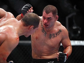 Cain Velasquez (right), seen here fighting Junior Dos Santos at UFC 166 a year ago in Houston, was forced to withdraw from his headlining title fight against Fabricio Werdum next month. (Andrew Richardson/USA TODAY Sports/Files)