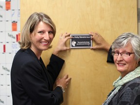 Lorraine Schatzler, CMHA Middlesex, Strathroy Site Manager (left) and Vicky Stevens, former Executive Director of Search Community Mental Health Services (right) place a plaque on the newly-dedicated Vicky Stevens Room. Stevens is a long-time mental health worker of more than 36 years.