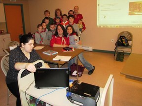 Using a laptop and a projector, Ardis Chedore, (foreground) Program Coordinator for Cochrane Public Library, linked Scouts in the UK and our Cochrane Cubs and Scouts to see each other over Skype.