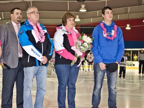 Ryan Leonard, General Manager and Head Coach of The Cochrane Crunch, Dianne St. Amant, Larry St. Amant, and Nick St. Amant stand during the singing of O Canada at Friday night's Cochrane Crunch game. Dianne who is battling breast cancer was being honoured during the team's Pink in The Rink fundraiser for her and for breast cancer research. she had just received flowers from the team and dropped the first puck.