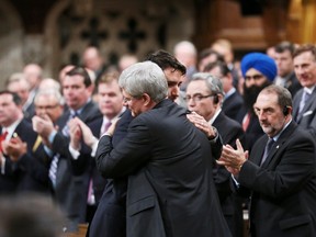 Prime Minister Stephen Harper, right, hugs Liberal Leader Justin Trudeau in the House of Commons in Ottawa on October 23, 2014. (REUTERS/Chris Wattie)