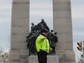 Police direct traffic away from the cenotaph near Parliament Hill in Ottawa on Wednesday Oct. 22, 2014. An arrest has been made after at least one person was shot in a hail of gunfire on Parliament Hill and the nearby cenotaph. Tony Caldwell/Ottawa Sun/QMI Agency
