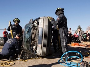 Members of Edmonton Fire Rescue Services Technical Rescue team demonstrate a trapped victim in a flipped car rescue during an EFRS training school open house in Edmonton, Alta., on Saturday, Oct. 18, 2014. Approximately 250 firefighter hopefuls showed up to learn about firefighting with Edmonton's firefighters. Ian Kucerak/Edmonton Sun